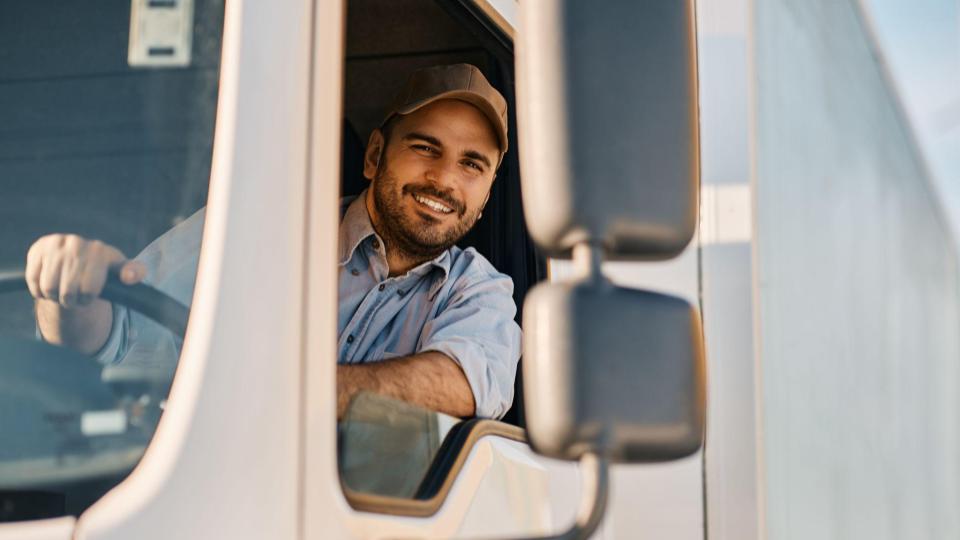 Trucker leans out window of semi cab