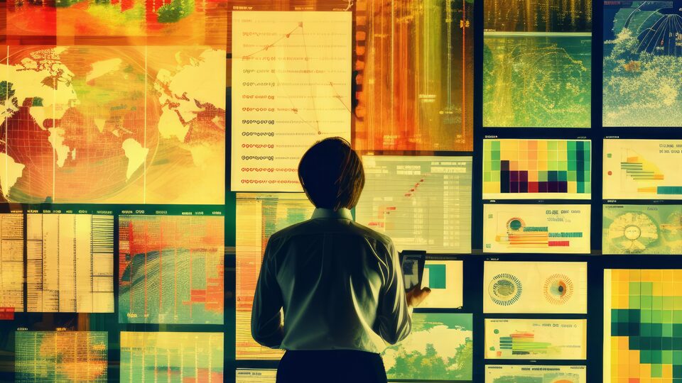 A marketer looks at a wall of screens displaying various graphs and charts.