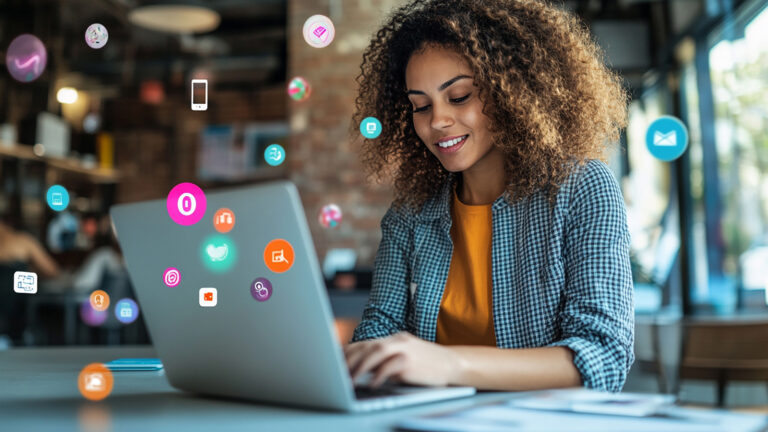 Smiling woman with curly hair working on laptop in café, surrounded by colorful digital app icons floating from screen