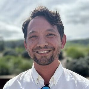 headshot of man outside smiling at camera