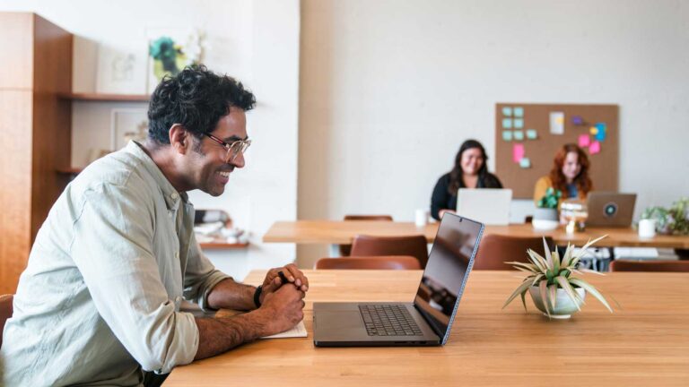 Man smiling at laptop thanks to more effective B2B lead generation.