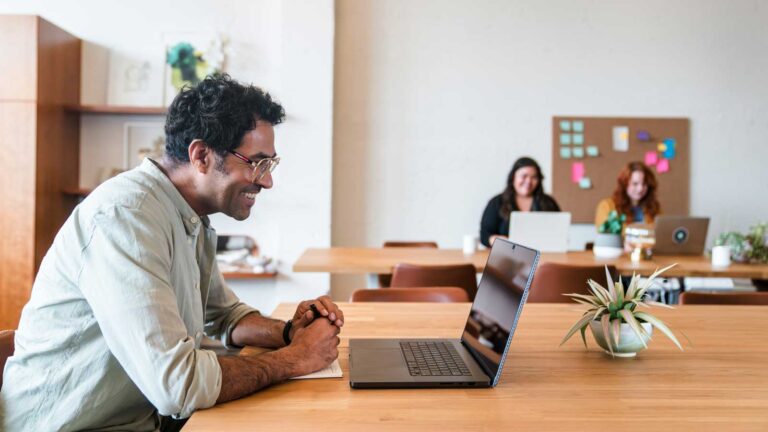 Man on laptop smiling.