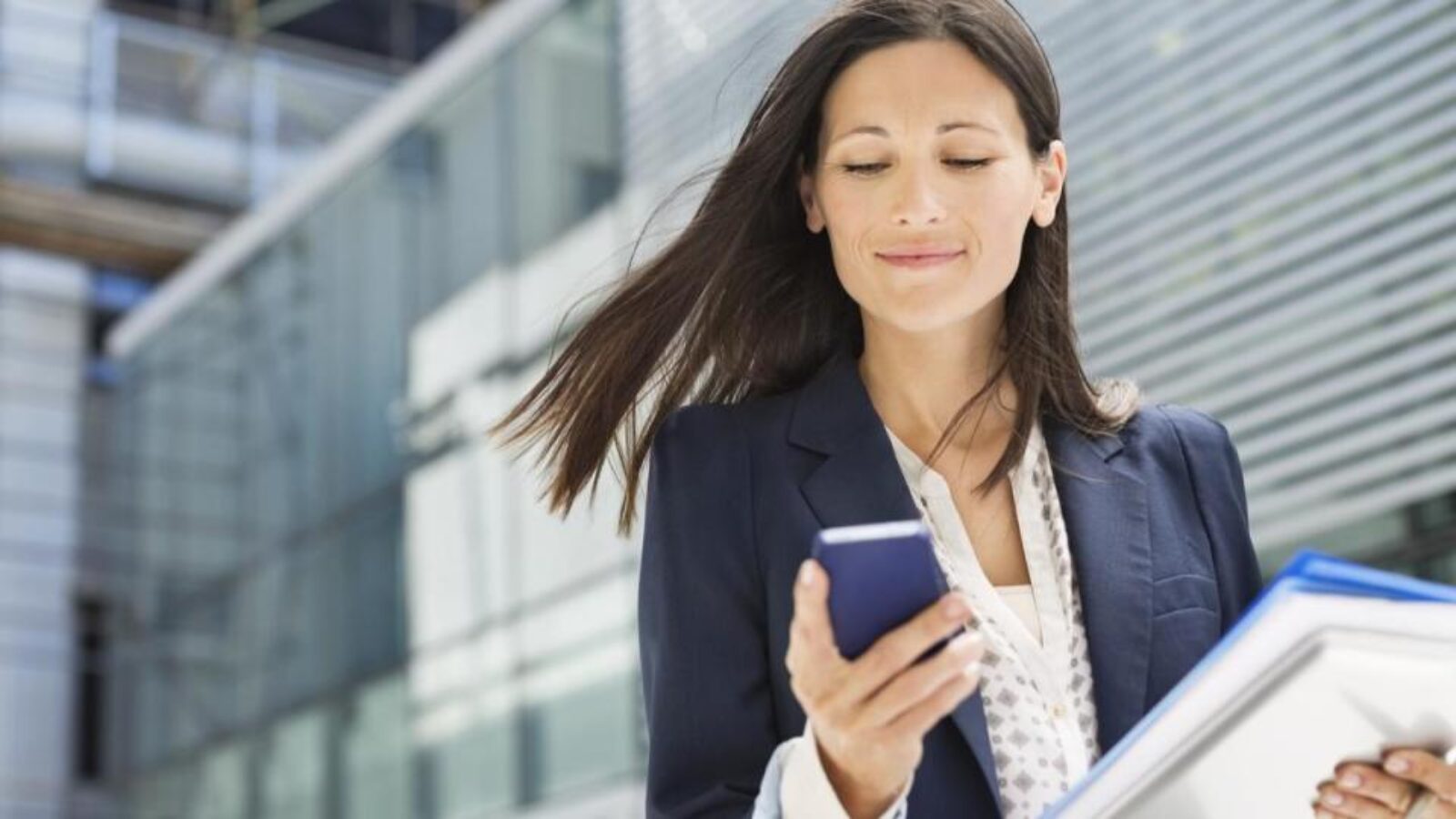 A businesswoman looks at a digital ad on her smartphone