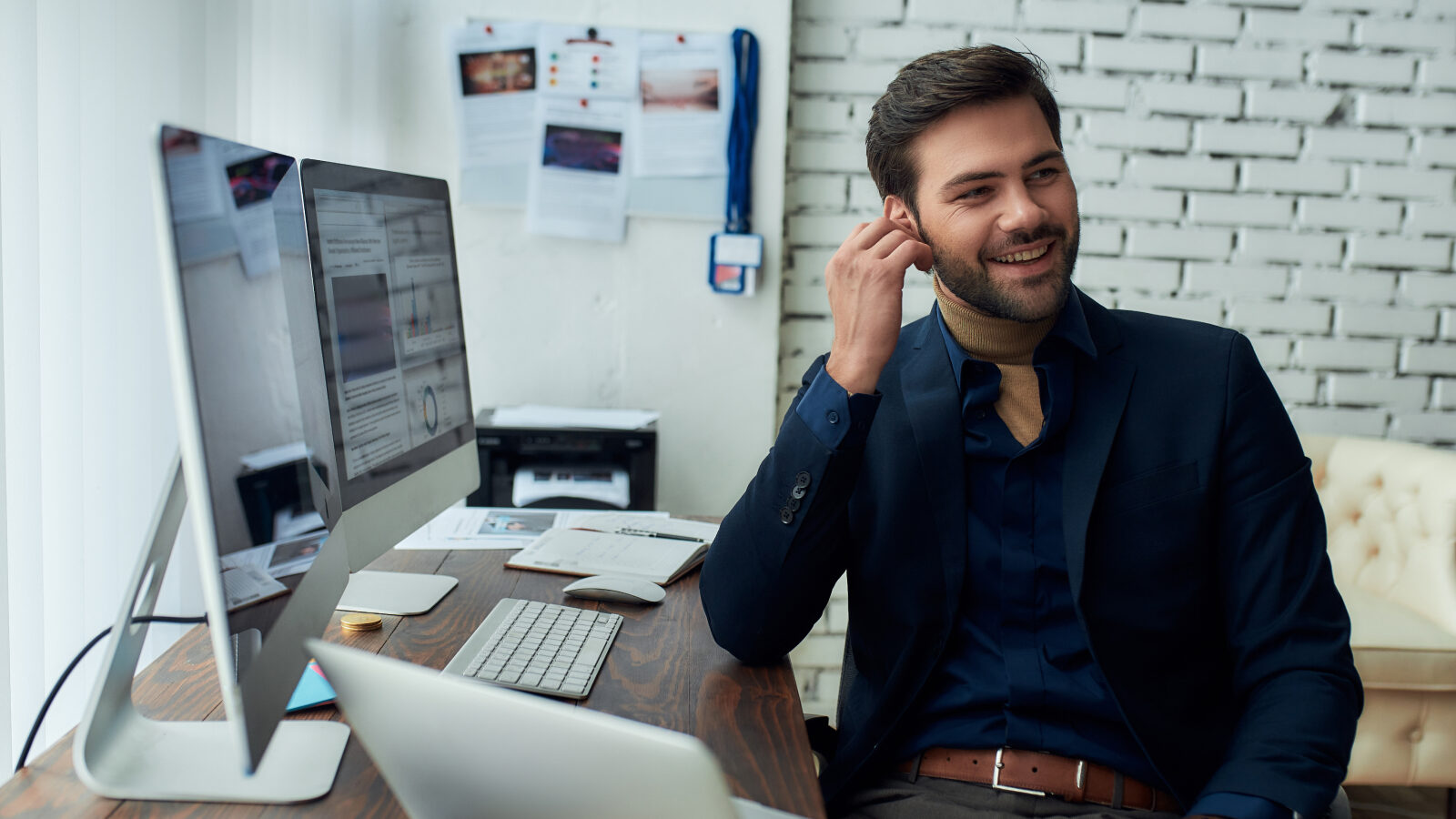 Successful young businessman using headset at his desk